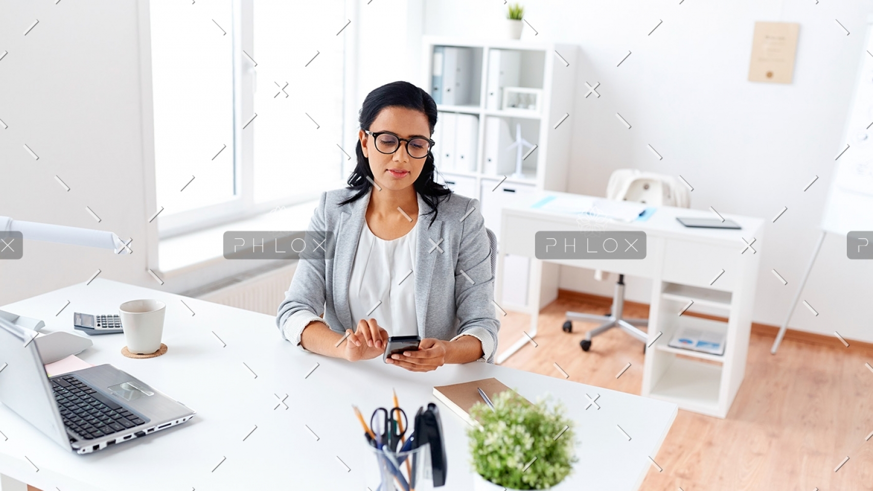 businesswoman-messaging-on-smartphone-at-office-P5AQU8Y